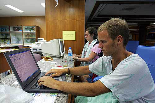 British tourist Richard Atkins (left) and Canadian tourist Christine Lang write emails to family members at Vachira Phuket Hospital, after they survived a devastating tsunami which hit the resort town of Phuket, on December 27.  Reuters