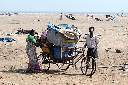 Hawkers at the Marina beach hit by tsunami waves collect their remaining goods, in Chennai on Monday.  PTI