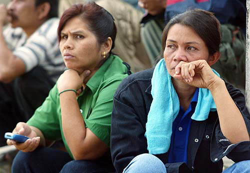 Two Thai woman wait for information from the rescuers about the status of their loved ones in Phang Nga province, about 788 km south of Bangkok, on December 28, after a tsunami hit the area on Sunday.  Reuters