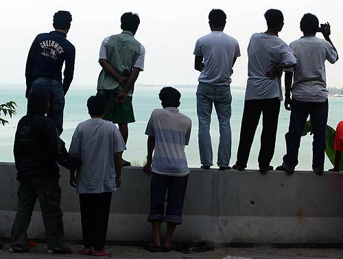 Locals look at the sea in Phang Nga province, about 788 km south of Bangkok, on December 28, after a tsunami hit the area on Sunday.  Reuters
