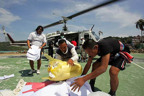 Rescue workers remove sheets used for covering bodies from a helicopter at Ton Sai Bay at Phi Phi Island, on December 28, two days after a tsunami hit the area.  Reuters