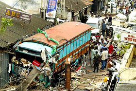 Lankan civilians walk around damaged vehicles on Monday 