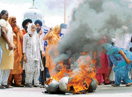 Members of the Kalgidhar Sevak Jatha burn helmets outside the Amb Sahib gurdwara, Phase VIII, in Mohali