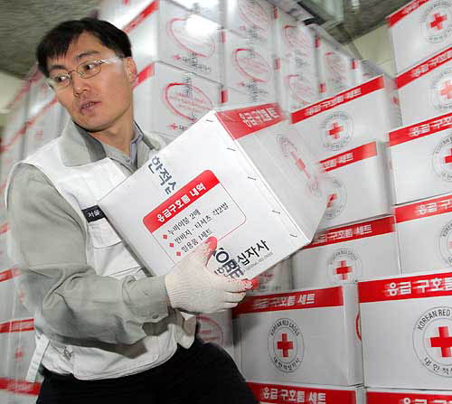 An employee at Korean Red Cross in Seoul organises emergency relief kits to be sent to Indonesia for victims of the weekend's quake-triggered tsunami, on December 29. Stricken countries on the Indian Ocean worked swiftly on Wednesday to bury thousands of bodies, as experts warned disease could kill as many as the 68,000 already dead from the violent crush of Sunday's tsunami.  Reuters