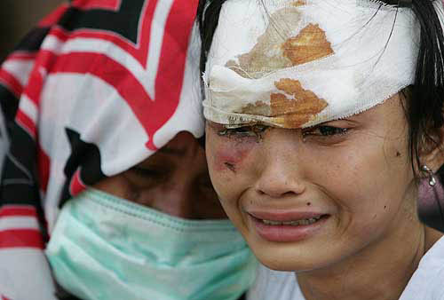 Two women weep as they wait for medical treatment at a military hosptial in Banda Aceh, Indonesia, on December 29, after a tsunami hit the area on Sunday.  Reuters