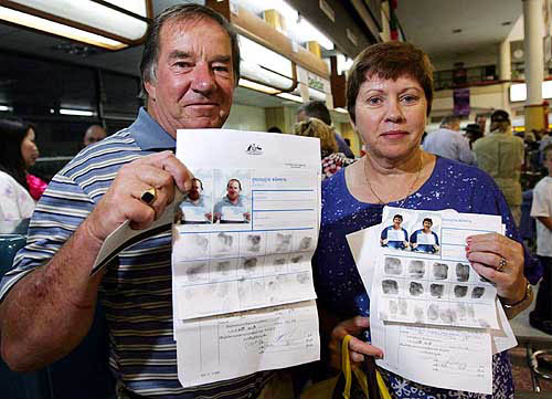 Australian tourists Trevor (left) and Sandra Pickering at Phuket airport on December 29 show their identity papers with their photographs and fingerprints, issued by Thai authorities after they lost their passports when tsunami hit the Thai resort island of Phuket. The couple were waiting to board a charter flight to Australia on Wednesday.  Reuters