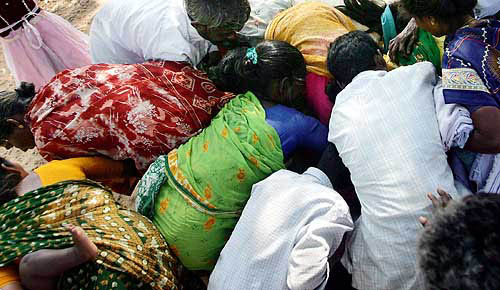 Survivors of Sunday's tsunami grab clothes donated by voluntary organisations at a relief camp in Cuddalore, about 180 km south of Chennai, on December 29. Thousands of corpses rotted in Indonesia's tropical sun on Wednesday as rescuers scoured isolated coasts across the Indian Ocean for survivors of Sunday's giant waves that killed more than 70,000.  Reuters