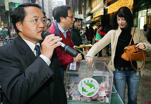 Newly elected Democratic Party chairman Lee Wing-tat (left), who was on holiday in Phuket when the tsunami hit the Thai resort, asks for donations at Hong Kong's financial Central district on December 29 to help victims of a massive quake-triggered tsunami that swept across Asia over the weekend.  Reuters