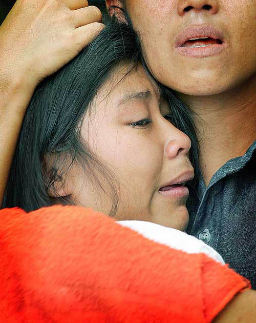A young Thai girl is comforted by her family member during the cremation of their relative, who was killed by Sunday's tsunami, in Thap Lamu, about 900 km south of Bangkok, on December 29.  Reuters
