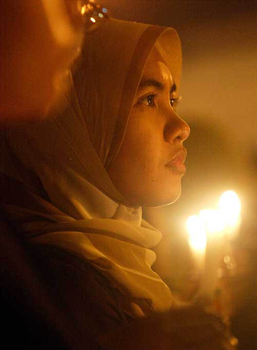 An Indonesian woman holds a candle during a candlelight vigil in Jakarta on December 29, for victims of tsunami-hit Aceh.  Reuters