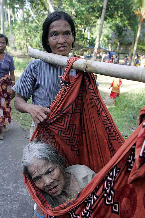 An Indian woman carries her mother while they leave the Car Nicobar island after the tsunami hit on Sunday in the remote Andaman and Nicobar islands chain, near the epicentre of the quake, on December 29.  Reuters