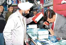 Forensic experts take fingerprints at a mobile phone shop which was burgled in Ghumar Mandi, Ludhiana
