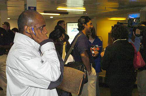 Sri Lankan cricketer Sanath Jayasuriya speaks on his cellphone after arriving at the Auckland Airport in New Zealand, on December 30. The Sri Lankan cricket team has withdrawn from its tour of New Zealand, ending days of anxiety for players separated from families in their tsunami-ravaged homeland.  AP/PTI