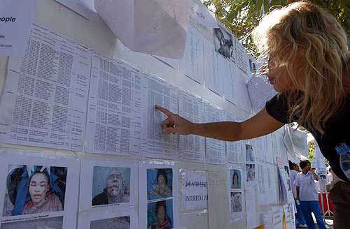 A western woman checks lists of dead persons put up on the wall at the Phuket city hall in Phuket province, southern Thailand, on December 30. International teams and more than 13,000 Thais were mounting the country's largest ever rescue and relief operation, with Prime Minister Thaksin Shinawatra fearing the death toll will soar.  AP/PTI