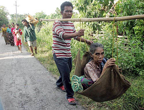 A Nicobari tribesman carries his mother as they leave the Car Nicobar island, on December 29, after a tsunami hit the remote Andaman and Nicobar islands chain, near the epicentre of the quake, on Sunday. Rescuers in India's Andaman and Nicobar isles struggled on Thursday to assess the toll from this week's tsunami in areas untouched by the modern world.  Reuters