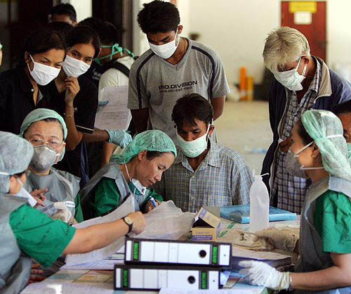 Thais provide health officials with information of missing family members that they may be located amid hundreds of corpses at a temple in Ban Muan, nearly 130 km north of the Thai resort island of Phuket, on December 30.  Reuters