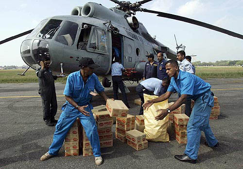 Soldiers carry boxes of biscuit for the survivors of a tsunami triggered by an earthquake in Sri Lanka's southern city of Galle, on December 30.  Reuters
