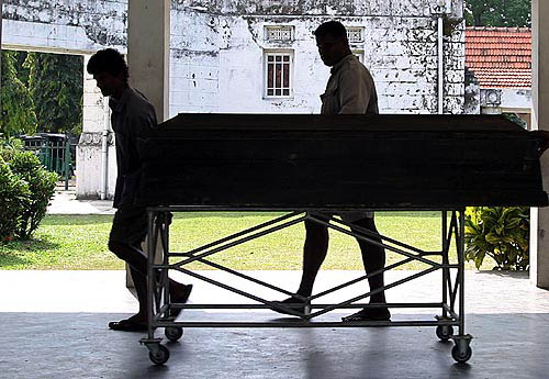 Sri Lankan workers pull a trolley with the coffin of Italian tsunami victim Rassaella Piva in Colombo on December 30, that will be cremated in Borralla cemetery. Millions of people around the Indian Ocean scrambled for food and clean water on Thursday, with the threat of disease and hunger now stalking survivors of the most devastating tsunami on record.  Reuters
