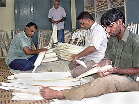 A group of workers shape up cricket bats at sport goods export house at Jalandhar