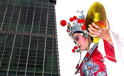 A singer from the traditional Taiwanese opera group, Min Hwa Yuan, holds a replica of an ancient gold ingot symbolising good fortune, prior to going into the worlds tallest building, Taipei 101, for a performance at its grand opening ceremony on Friday