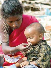 A woman feeds her child at a relief camp in Chennai on Thursday after the area was hit by a tsunami on Sunday.