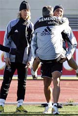 Real Madrids Brazilian soccer star Ronaldo carries a trainer in front of team-mate Guti during a training session in Madrid