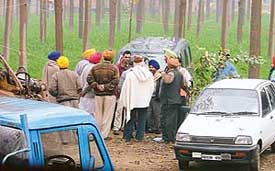 Villagers gather near the controversial farmhouse at Jainpur village in Ludhiana.