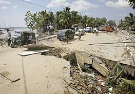 Cars ride past a destroyed road in the city of Galle, south of Sri Lanka, on Friday.