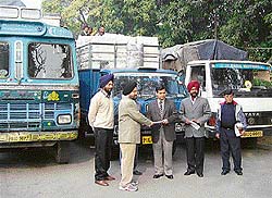Deputy Commissioner Anurag Verma receives a cheque from a city industrialist before flagging off a truck of relief material for the Chief Ministers Relief Fund
