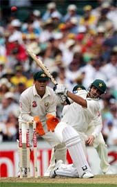 Pakistans Salman Butt hits a boundary as Australias Adam Gilchrist looks on during the first day of the third Test in Sydney on Sunday. 