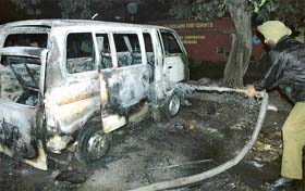 A fireman tries to control the fire in a van at Sector 7 Chandigarh, on Monday. 