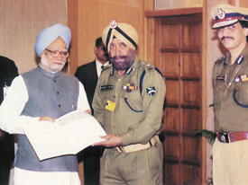 ITBP Director-General K.J. Singh persenting a cheque of Rs 70 lakh to Prime Minister Dr Manmohan Singh for the tsunami-affected victims in the Capital