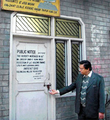 An official of LIC Housing Finance checks the lock of a defaulters property that was sealed in Kishore Nagar, Ludhiana