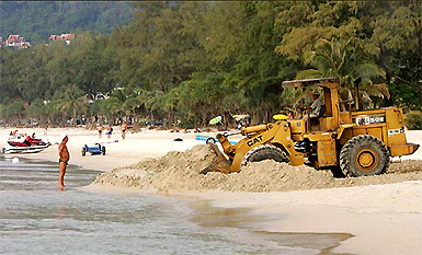 Werner Theebs (66) from Berlin, Germany, watches a tractor rebuild parts of Patong beach on the Thai resort island of Phuket on Wednesday