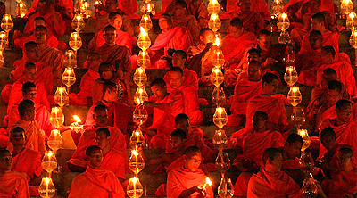 Buddhist monks light candles during a mass prayer session for tsunami victims on the Thai island of Phuket