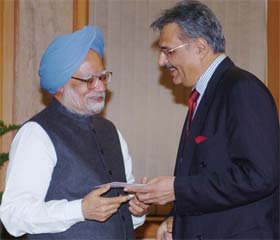 Prime Minister Manmohan Singh receives a cheque for the Prime Ministers Relief Fund for tsunami victims from ITC Chairman Y.S. Deveshwar