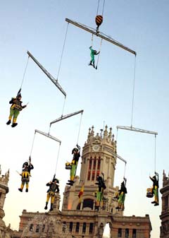 A group of drummers perform suspended from a crane above Madrid's Cibeles Square