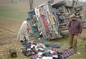 A policeman inspects the remains of bus which skidded of the road near Pampore, 20 km from Srinagar, on Friday.
