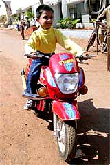 A boy rides a bike assembled by Jagdish Muddennavar, a young entrepreneur, in Hubli