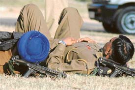 Two police personnel take rest after a hectic day in Chandigarh on Friday