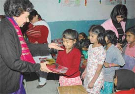 Ms Jean Rodrigues, wife of the Punjab Governor and UT Administrator, distributes sweaters among children at Government Primary School, Indira Colony, Mani Majra