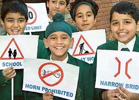 Schoolchildren hold placards with traffic signs on the concluding day of the 16th Road Safety Week at Traffic Police Line, Sector 29, in Chandigarh