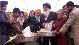 Former Chief Minister Parkash Singh Badal distributes ration and household articles among widows and destitute women in Ludhiana on Sunday