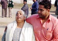 The mother of Harpreet Singh, who was murdered along with his wife, is being consoled by a relative in Ludhiana on Sunday