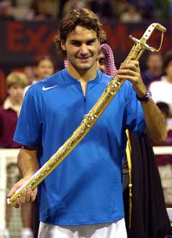 Roger Federer of Switzerland shows the sword presented to him after he beat Croatias Ivan Ljubicic