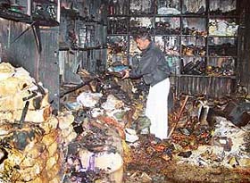 Narinder Kumar collects remains from his shop that was destroyed in a fire at Dhakauli village, near Zirakpur