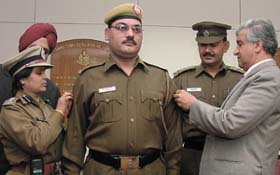Constable N.S.Rawat and ASI Braham Dev being promoted by the Commissioner of Police, Dr K.K.Paul, in the Capital