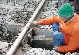 An employee of Northern Railway points at the repaired line with clumps which developed a fracture in Ludhiana on Monday