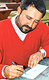 Amandeep Johal, golfer, signs a cheque for Rs 1 lakh as donation for the tsunami victims
