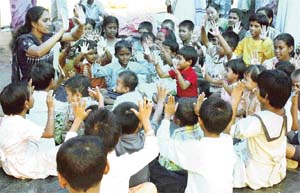 Homeless children being taught by a social worker at a relief camp for tsunami victims in Port Blair